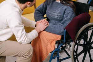 uomo accanto a persona disabile